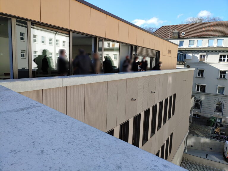 Besprechungsraum 3. OG vom Dachumlauf aus gesehen, Blick in den Innenhof Richtung Prinzregentenstraße. In den Fenstern spiegelt sich die Rückseite des Haupt-/ Eingangsgebäudes.